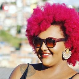Mulher com cabelos afro curtos e cor-de-rosa