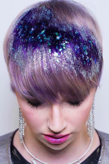 Mulher com cabelos curtos lilás e glitter na franja