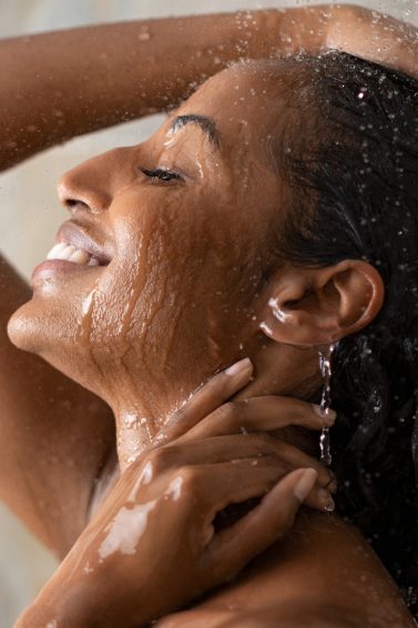 Mulher lava os cabelos debaixo do chuveiro