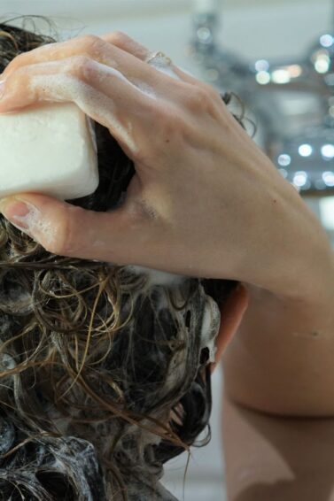 mulher lavando o cabelo com sabonete