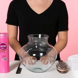 Mulher em mesa com shampoo, pente e escova