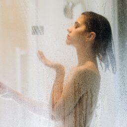 mulher de perfil com cabelos curtos tomando banho