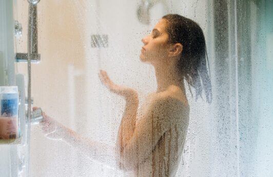 mulher de perfil com cabelos curtos tomando banho