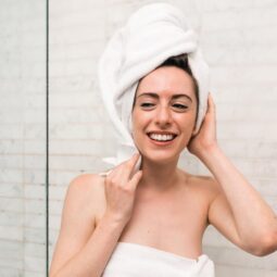 mulher saindo do banho com toalha na cabeça