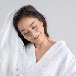 mulher enxugando o cabelo com toalha