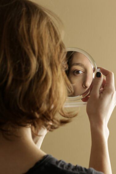 mulher se olhando em um espelho pequeno