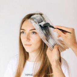 mulher passando tinta no cabelo