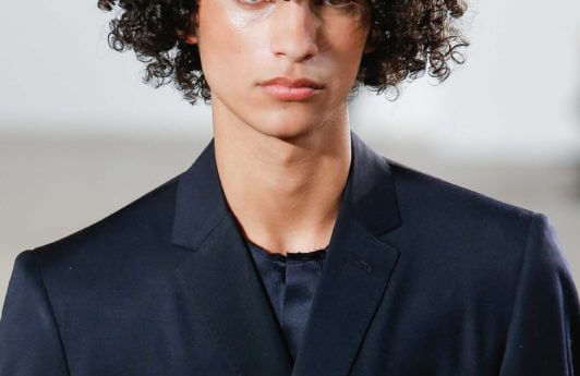 curly natural hair of a man in a navy suit