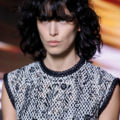 hairstyles for square faces: a model with wavy black long hair looking straight