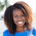 cheerful afro woman smiling outdoor wearing a blue t-shirt
