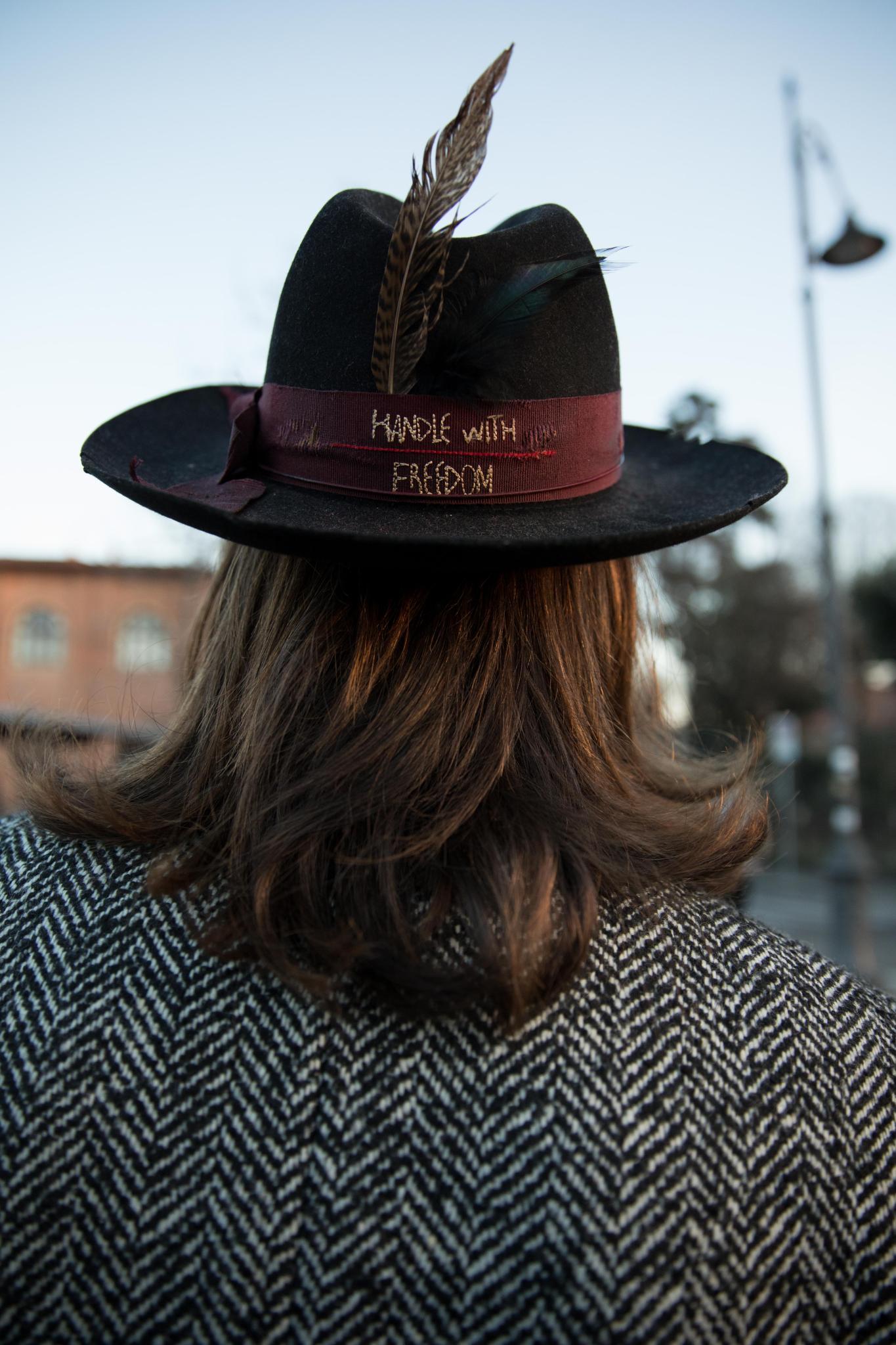 man with long hair wearing a hat
