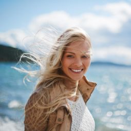 a blonde woman smiling on the beach
