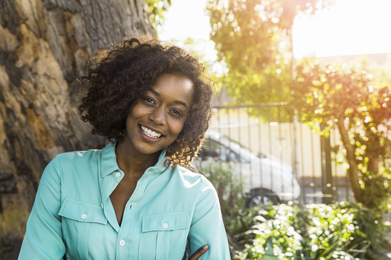 a curly short hair woman in the garden sunlighted