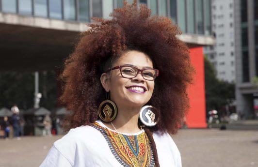 an afro woman with reed thcik hair smiling outdoor