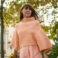 a beautiful woman wearing pink sweater walking in a park