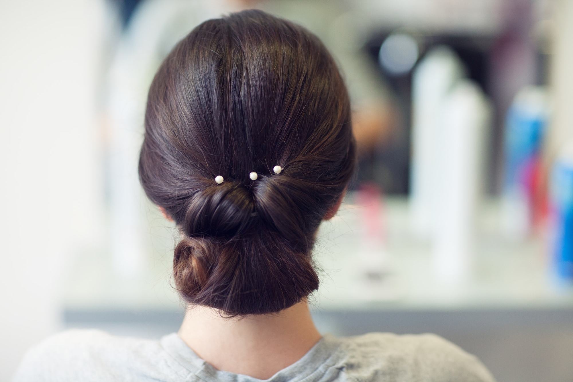 coiffed simple brunette low updo pearls