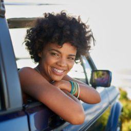 a cute woman smiling on the car