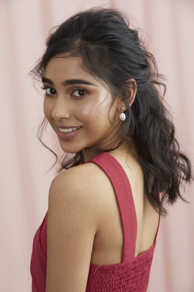 girl with dark hair and half updo and face-framing curls