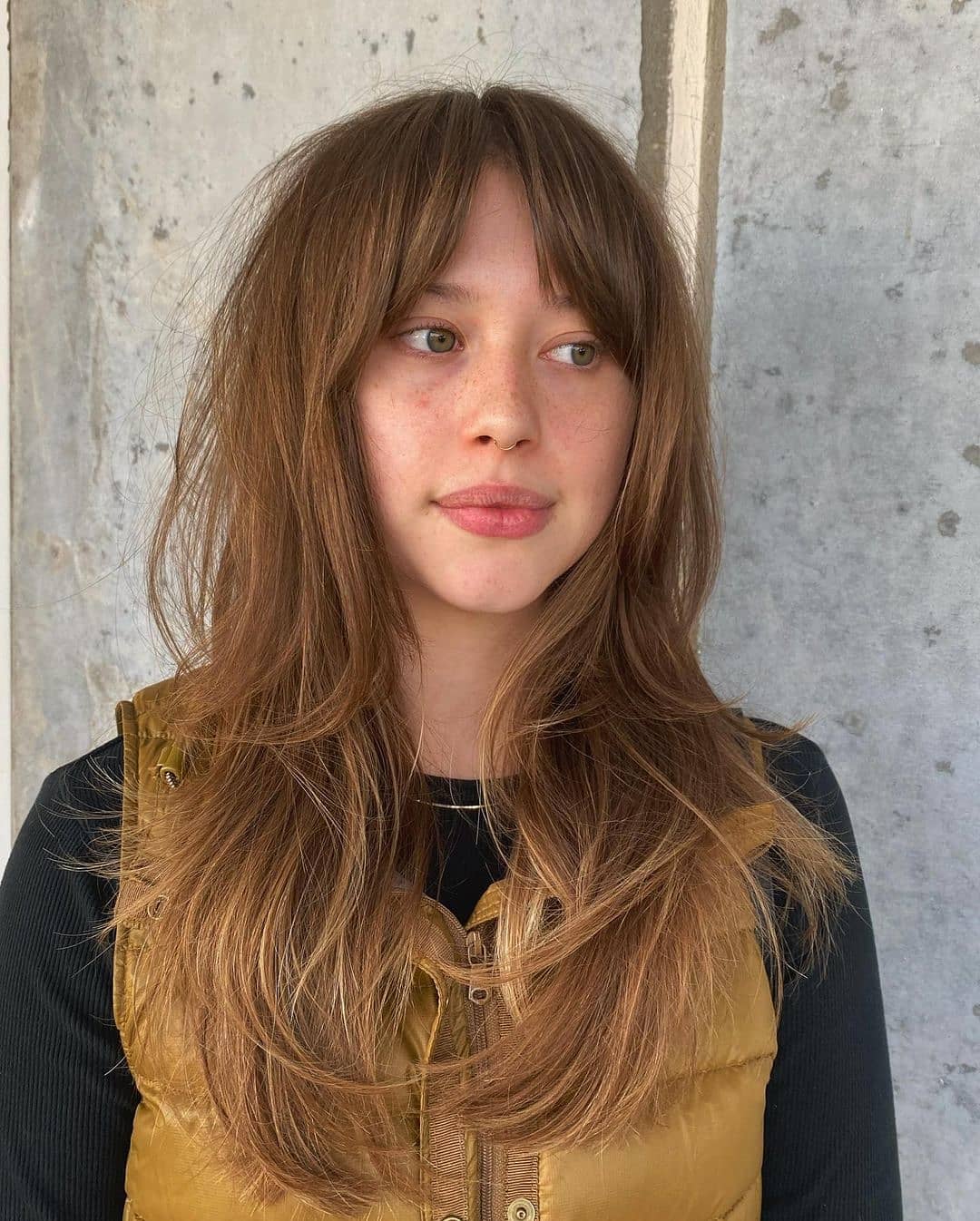 girl with bottleneck bangs on long brunette hair