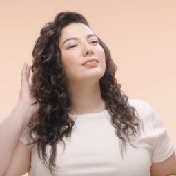 model showing final side part curly hair look on side angle