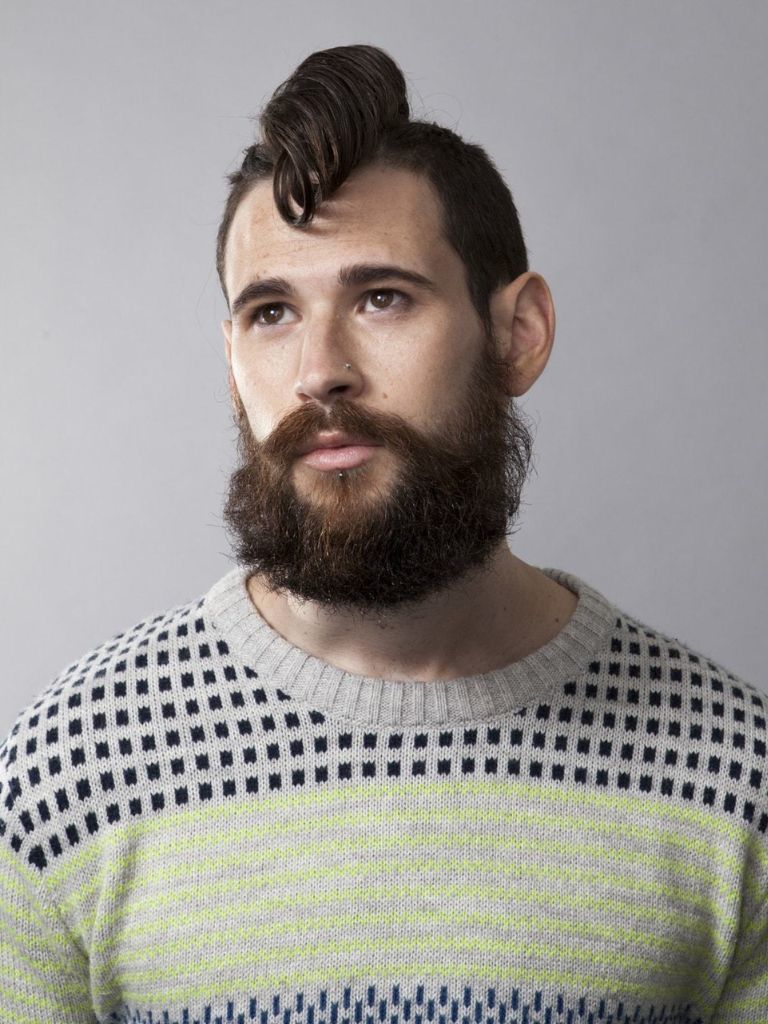 Man with a curly mohawk and mid-fade hairstyle.