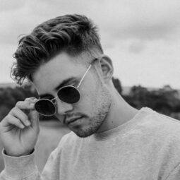 Man with medium fade hairstyle and sunglasses.