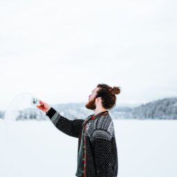 Man with viking hair in a man bun standing in the snow.