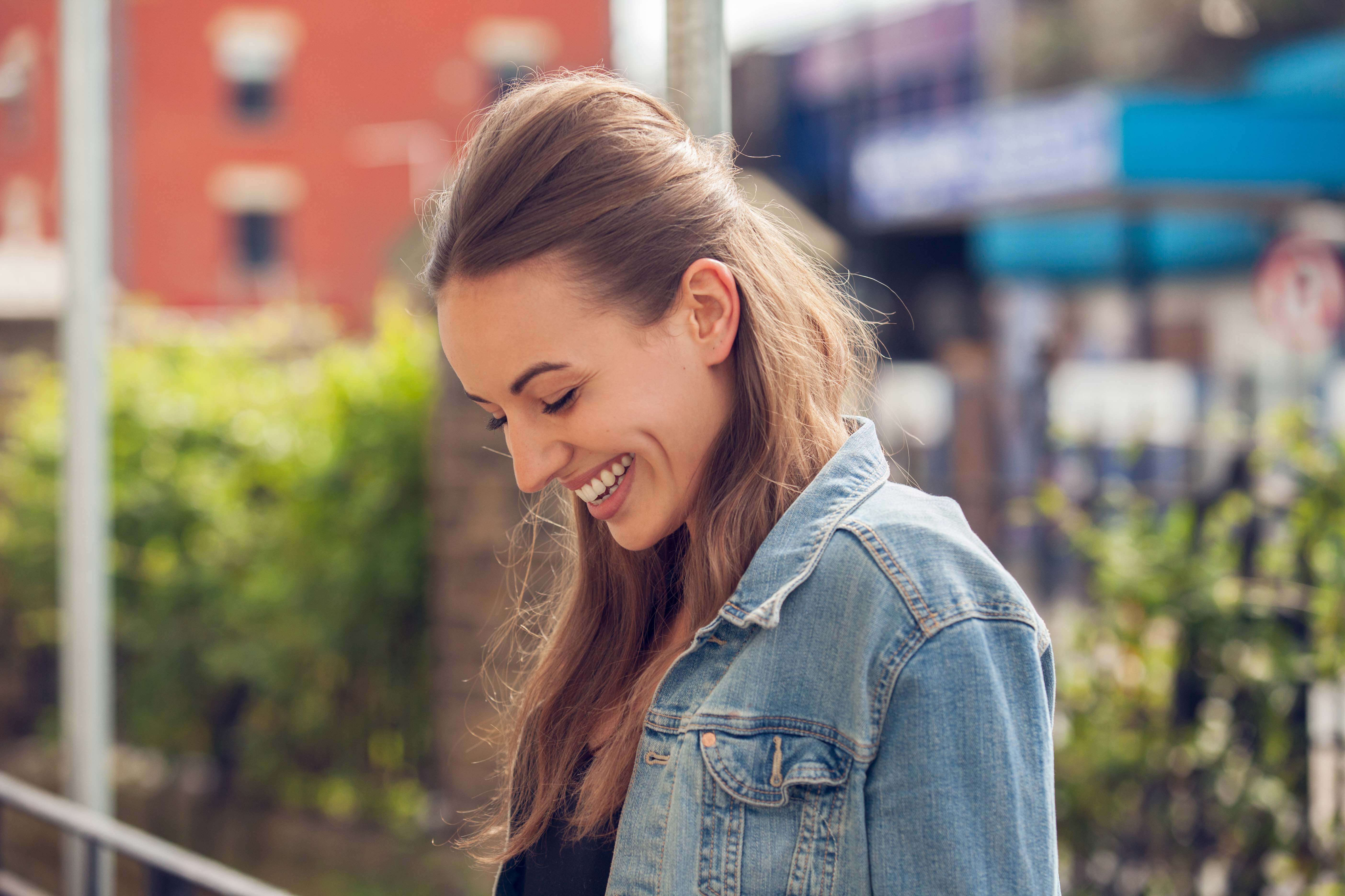 model with light brown blonde hair in a half-up beehive hairstyle wearing a denim jacket