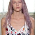 a female fashion mode with lavender hair walking on the runway