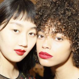 Two models backstage with straight and curly hair