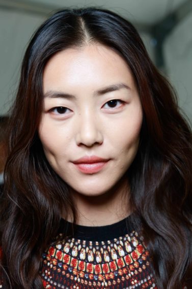 the best anti frizz serum: Young Asian model with wavy long dark brown hair from the DVF SS14 catwalk