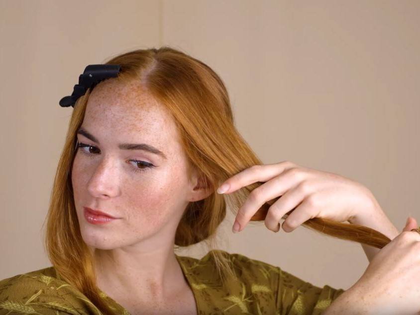 A red haired woman parting hair