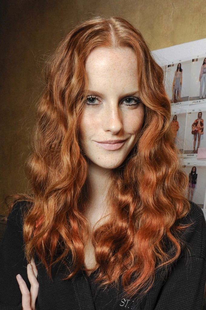 model with long loose waves and dark rose tinted copper hair