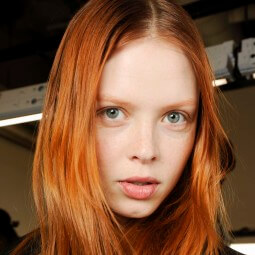 model backstage at fashion show with warm copper red hair