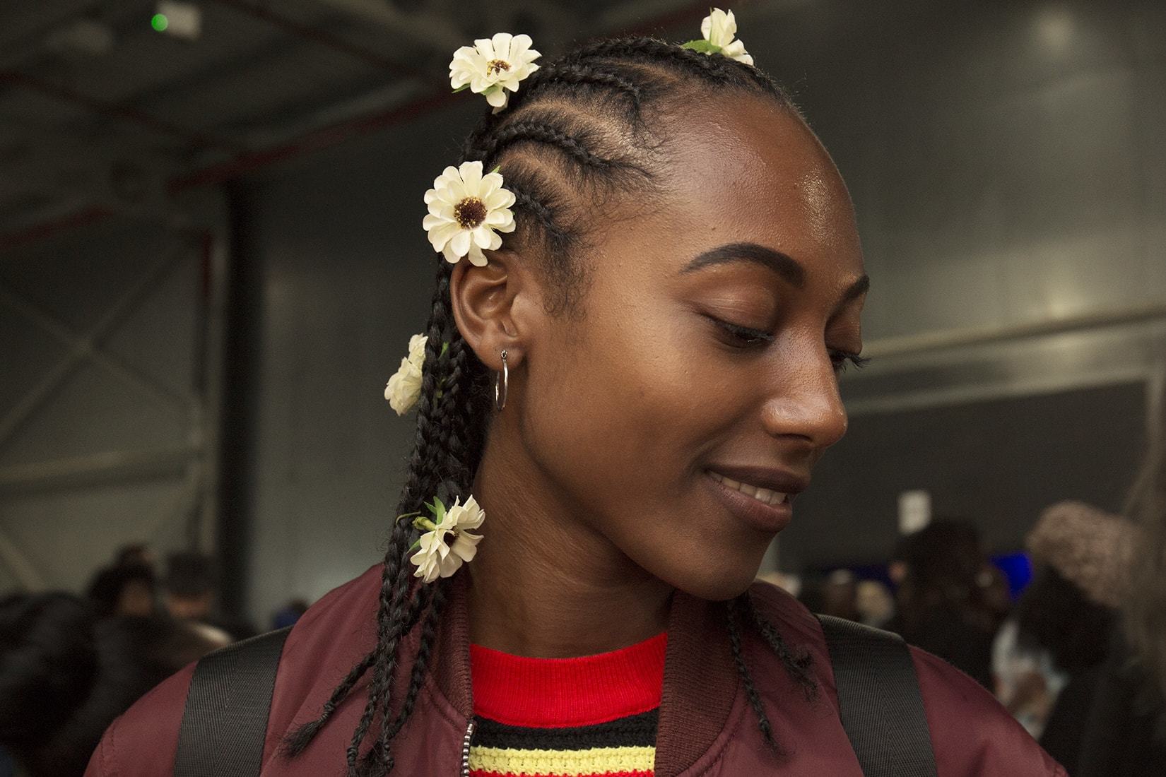 A black girl with cute cornrows and floral embellishments in her hair