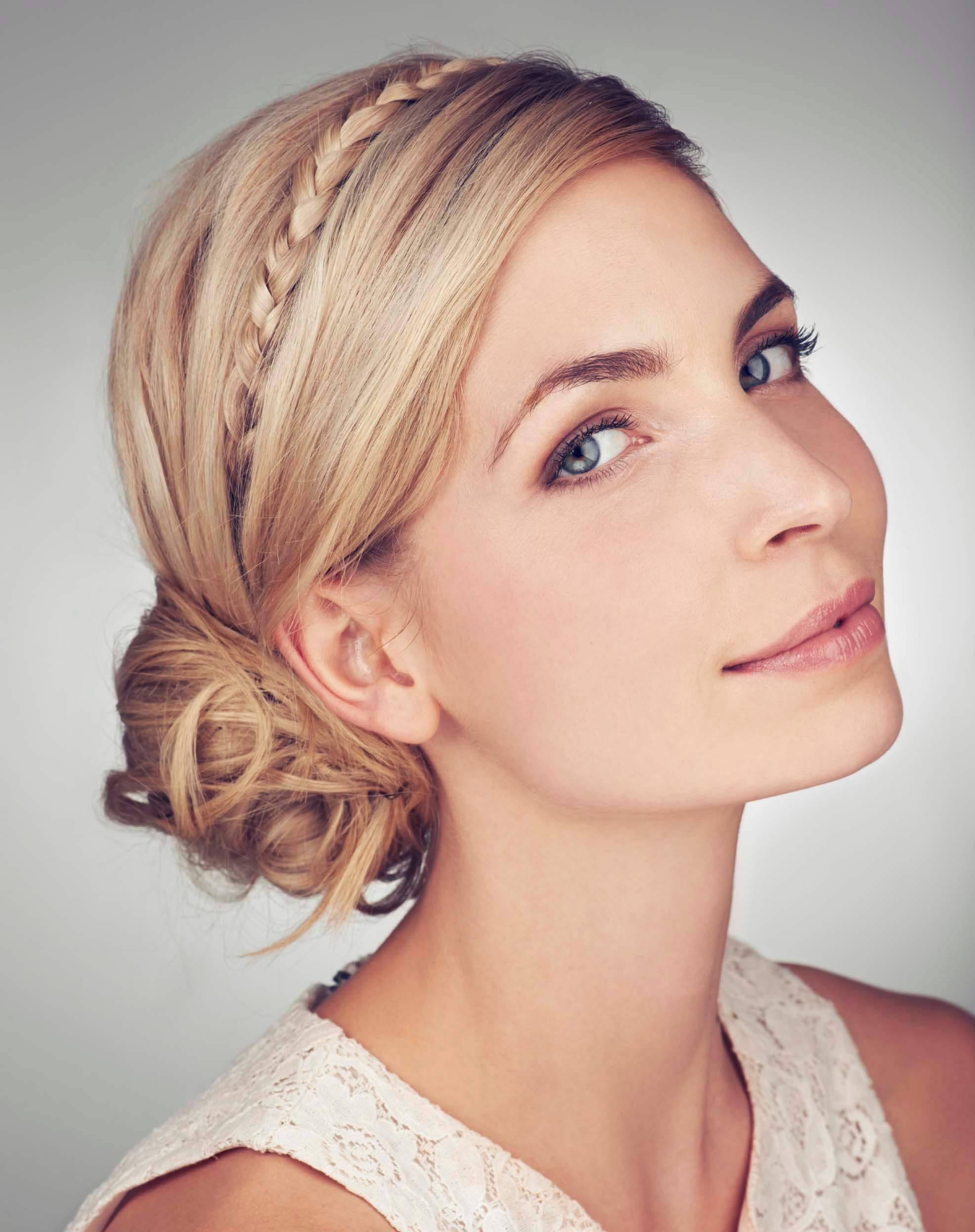 A blonde woman with low chignon hairstyle and braid