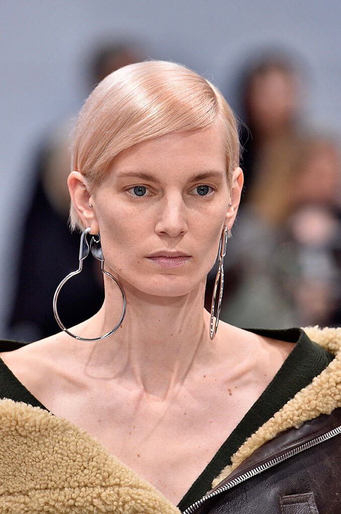 Blonde hair: Image of a woman with a pixie but and pink champagne shade blonde hair.