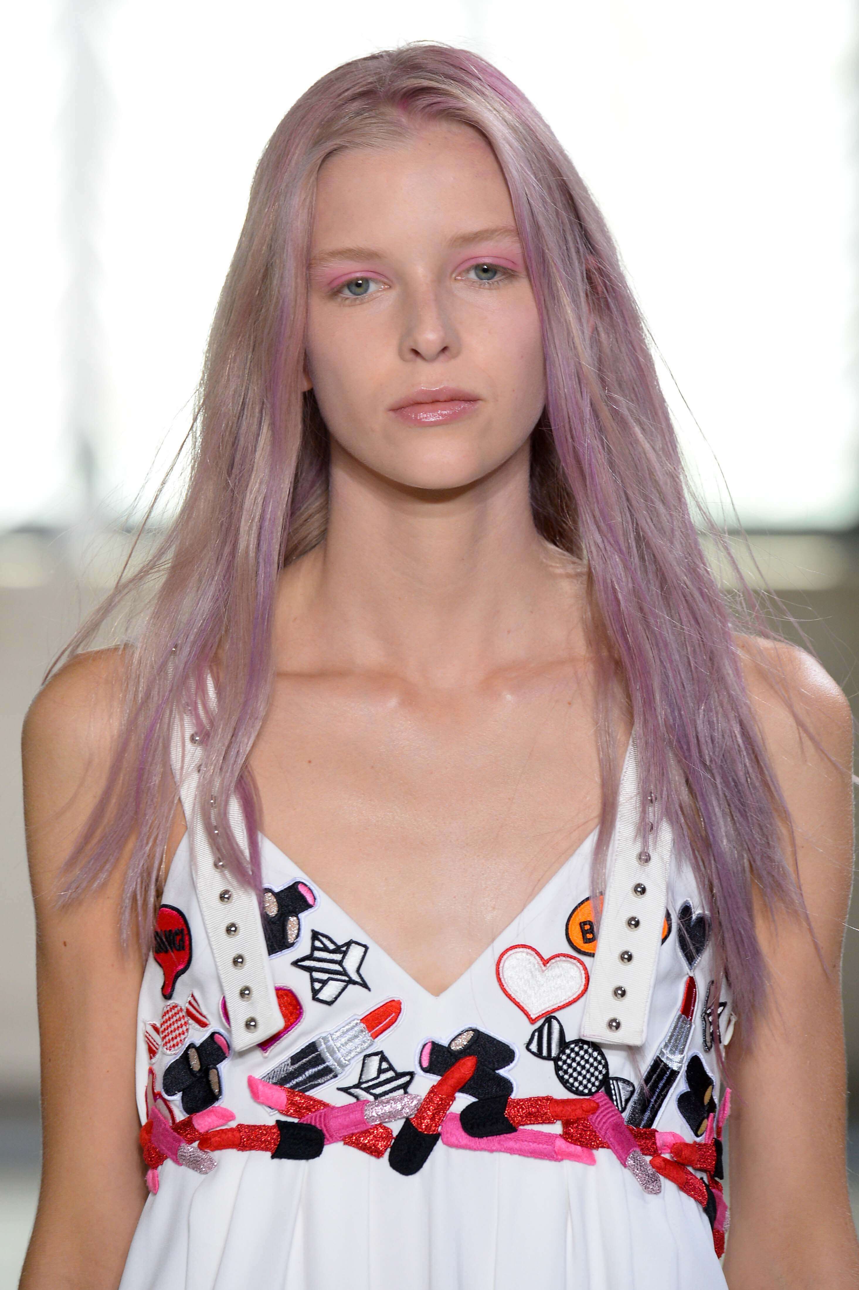 a female fashion mode with lavender hair walking on the runway
