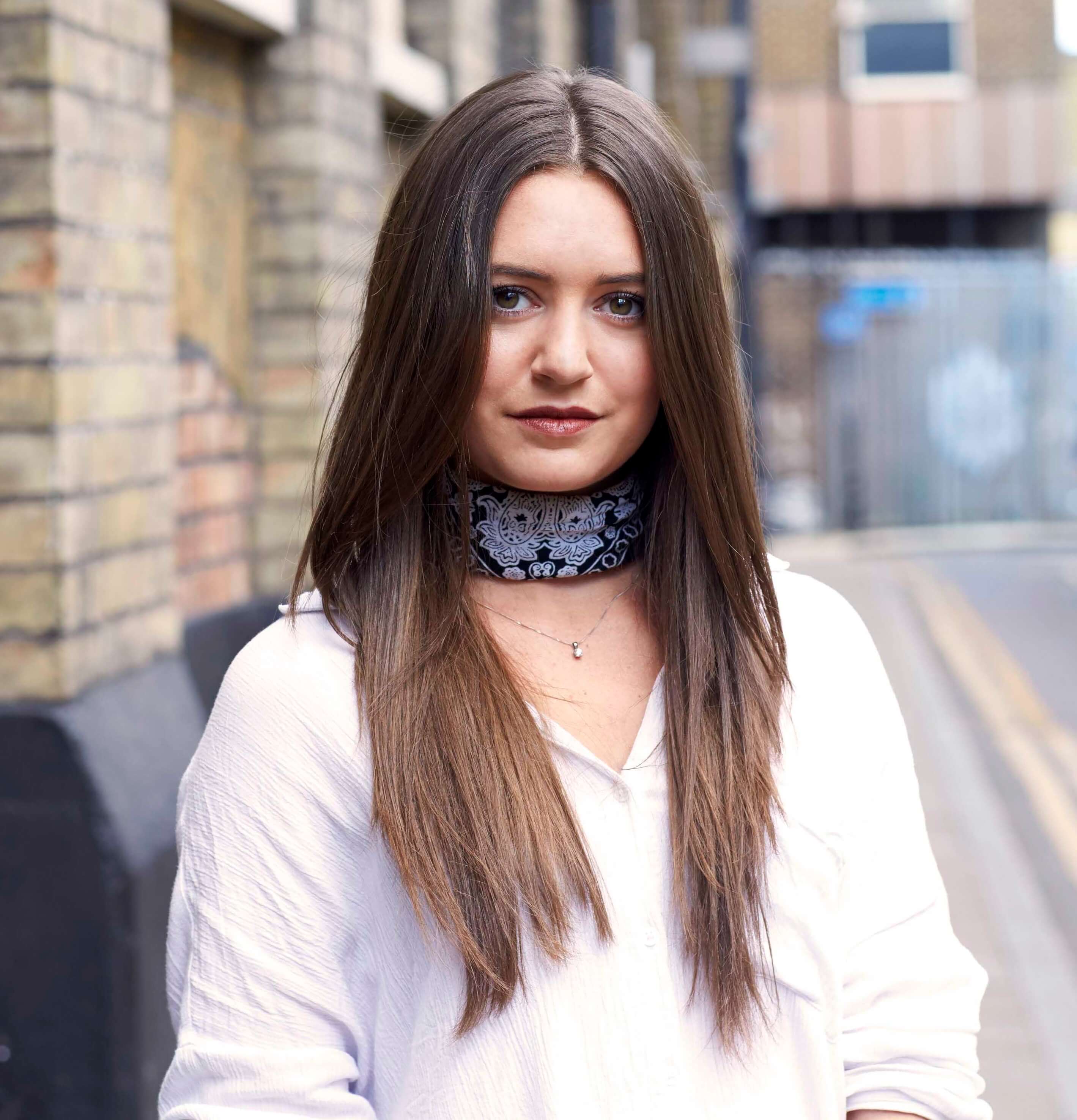 Haircuts for thick hair: Street style shot of a brunette woman with long hair with feathered layers