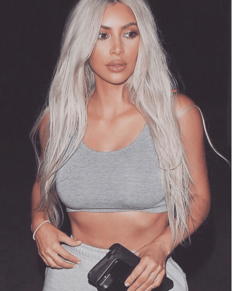 front view image of Kim Kardashian wearing a grey crop top with long blonde platinum hair