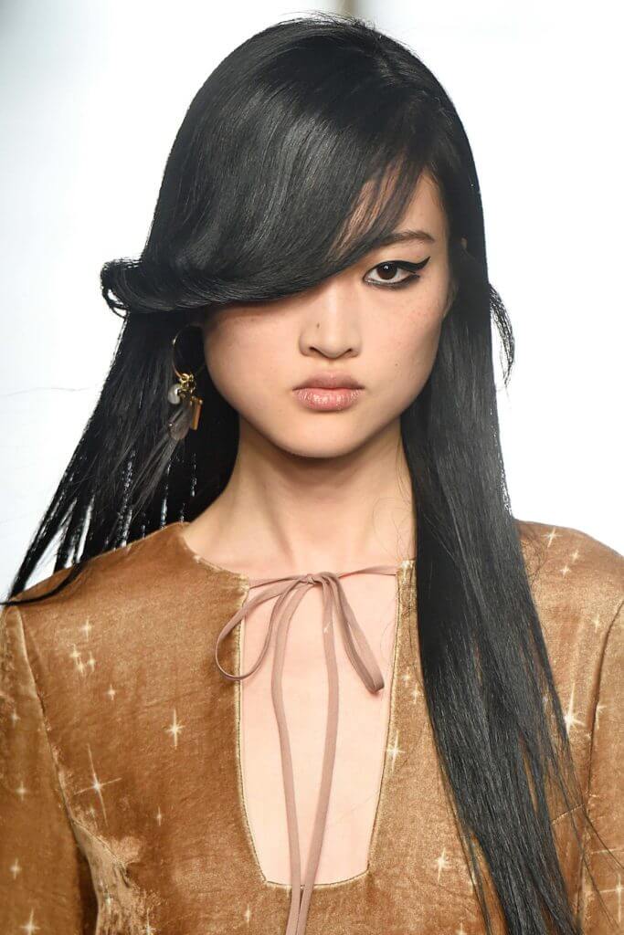 Asian woman with long hair and side swept bangs: hairstyles for round faces