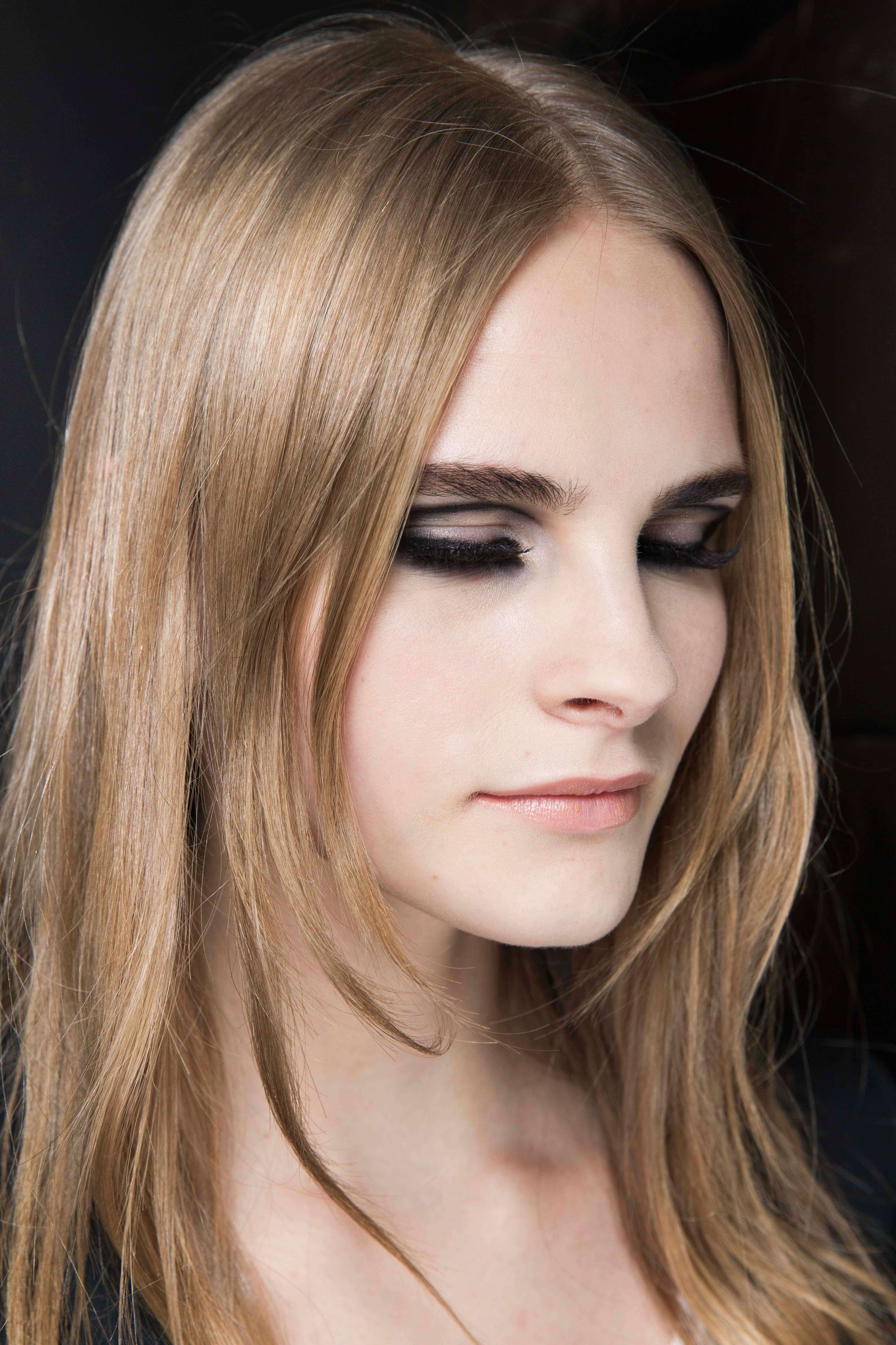 long layered haircuts: close-up of a dirty blonde model with wispy feathered layers