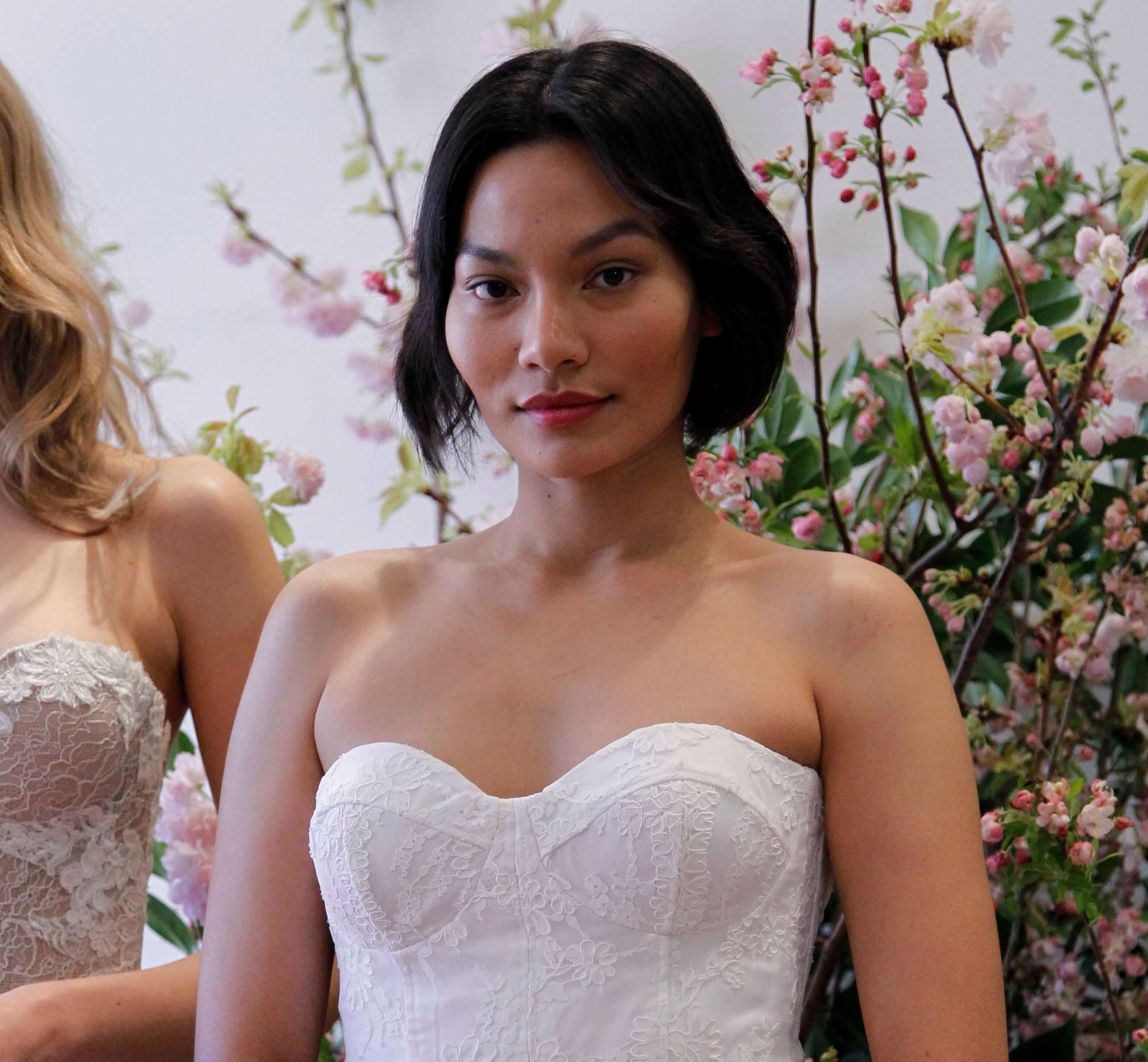 Wedding hairstyles for short hair: Woman with a dark brown wavy bob wearing a wedding dress.