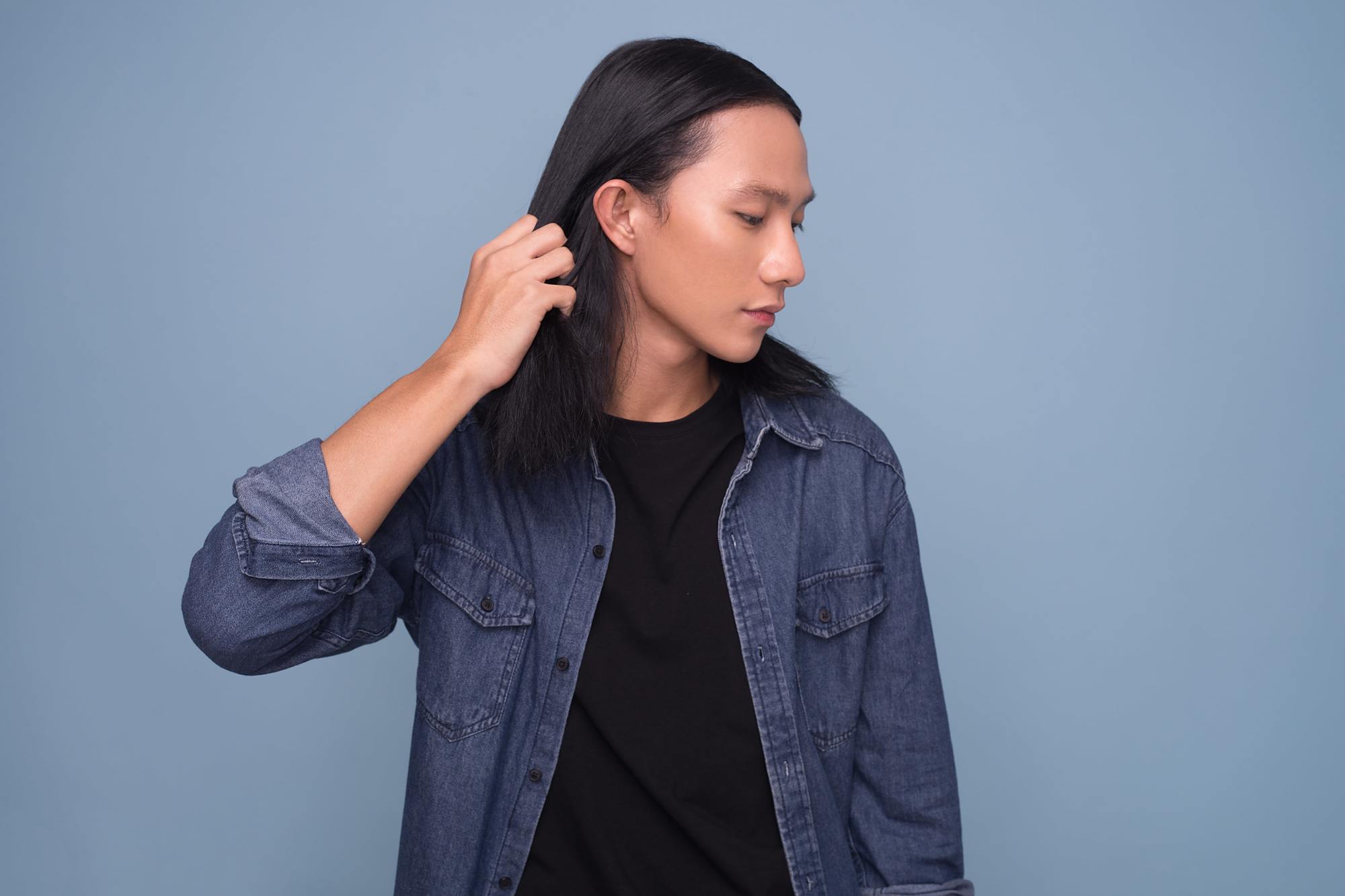 Asian men hairstyles: A young Asian man with shoulder-length straight hair