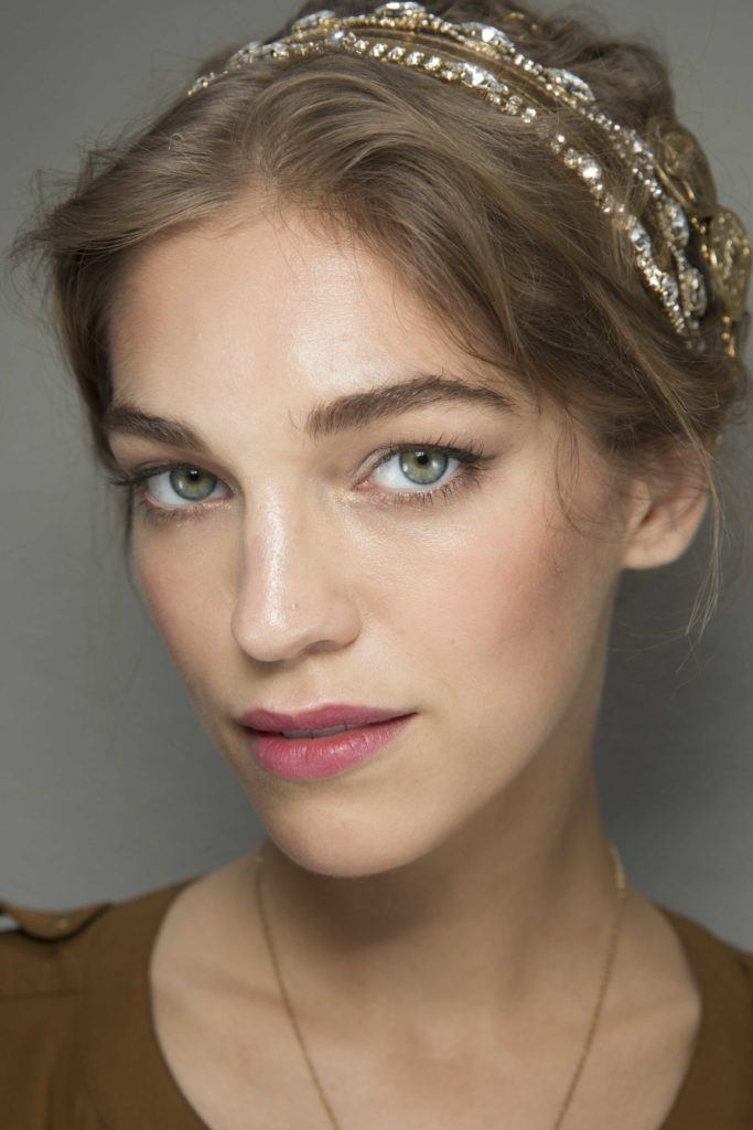 model with medium brown hair styled into an updo with an embellished hair accessories attached