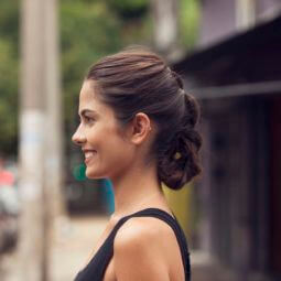 side view of a woman with a braided roll updo in dark brunette hair
