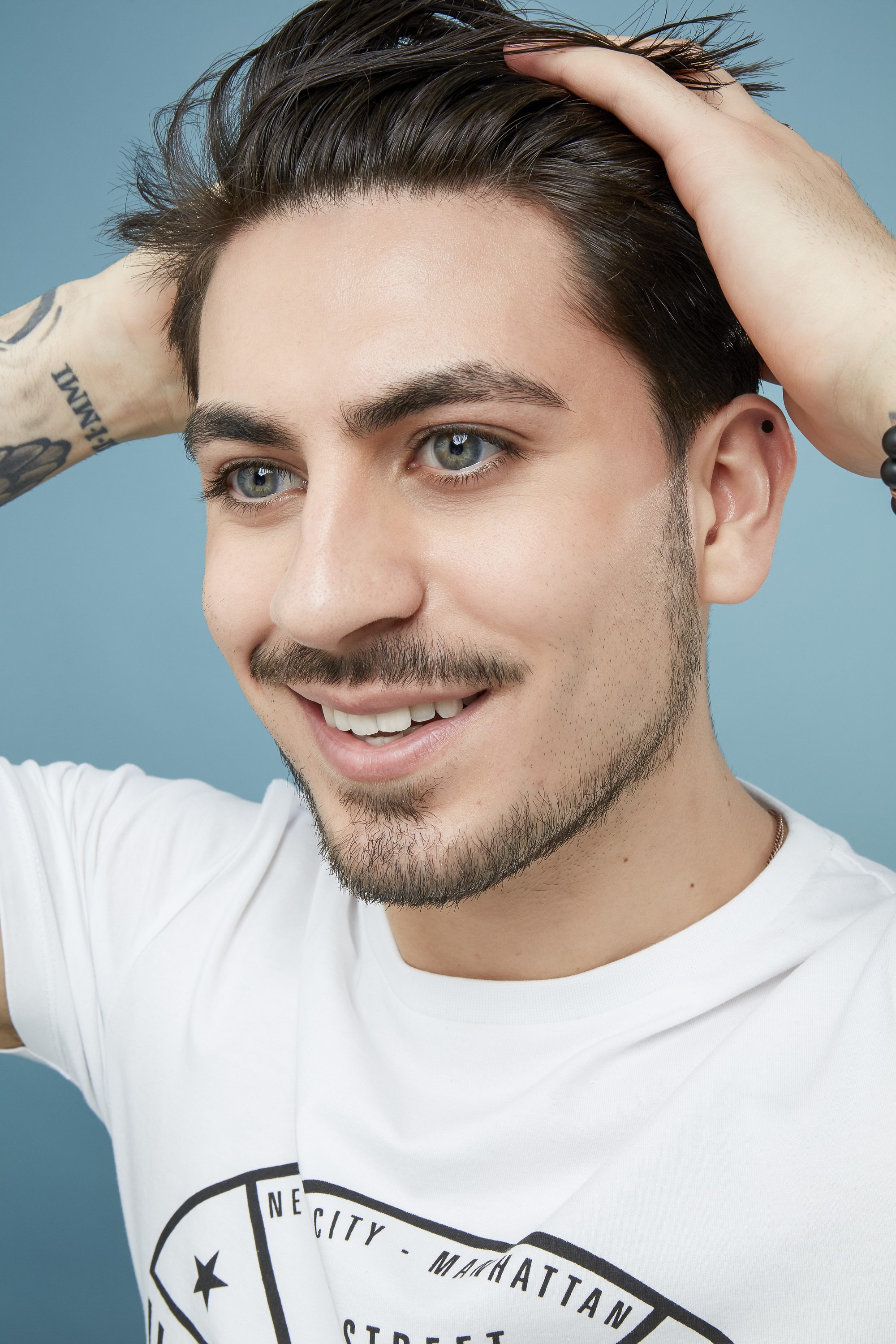 Hair wax for men guide: Close up shot of a man touching his dark hair.