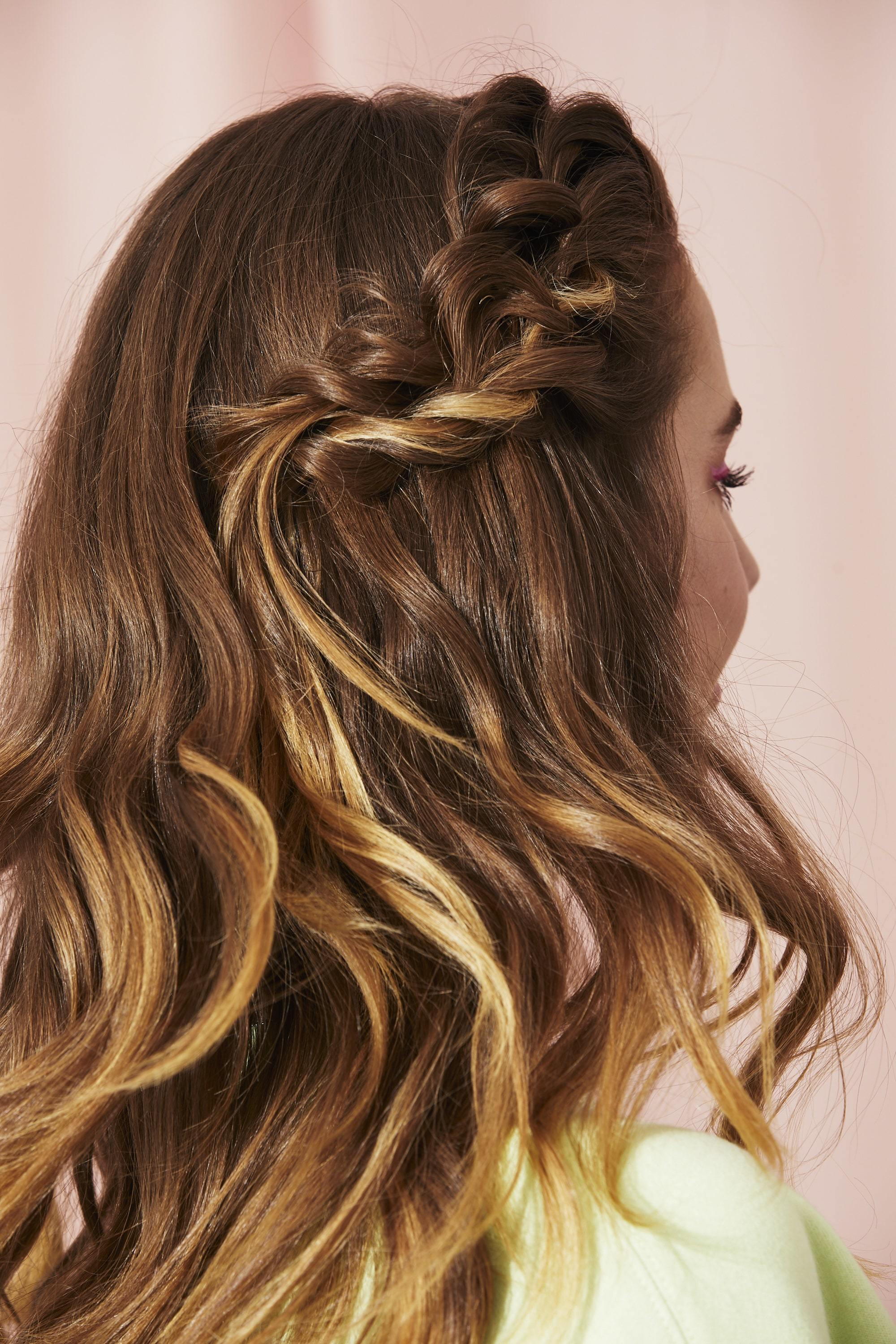 Woman with a half-up twisted braid style with messy waves
