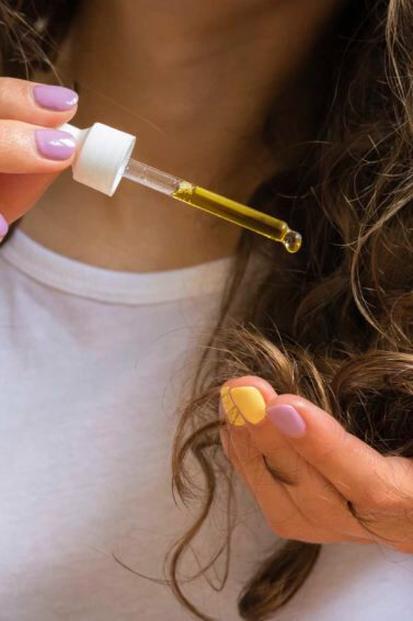 curly haired girl using hot oil treatment for hair