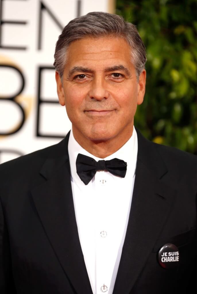 George Clooney on the red carpet with a grey quiff in a tuxedo